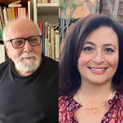 a man in white beard and dark shirt before shelves of books; a woman in straight brown hair and red shirt, both poets are smiling