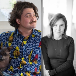 two poets, one in colored shirt, fancy mustache, two grey dogs under their arm; one with brown straight hair, dark o-neck top before a window, smiling