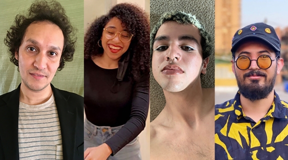 four poets: a man in dark curly hair, striped t-shirt and black sportscoat; a woman with long dark curls, red lipstick, in a black top; a person with short hair dyed silvery-green, eyeliner, and no shirt; a man in bold blue & yellow patterned shirt, blue cap, darkly bearded in a brilliant landscape
