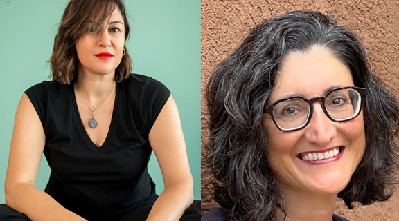 one woman with her hands crossed in her lap, wearing a dark low top with pendant necklace, before an aquamarine wall; a second woman in a wide smile and dark glasses, a textured earth colored wall behind her